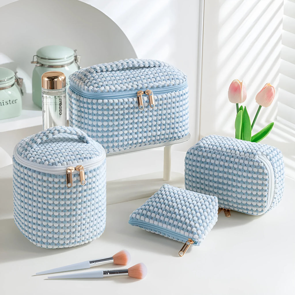 Set of four small pink cube-shaped flannelette makeup bags with zips, arranged together.