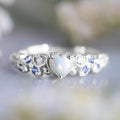 A white alloy heart-shaped ring for women on a plain background, showing the heart design.