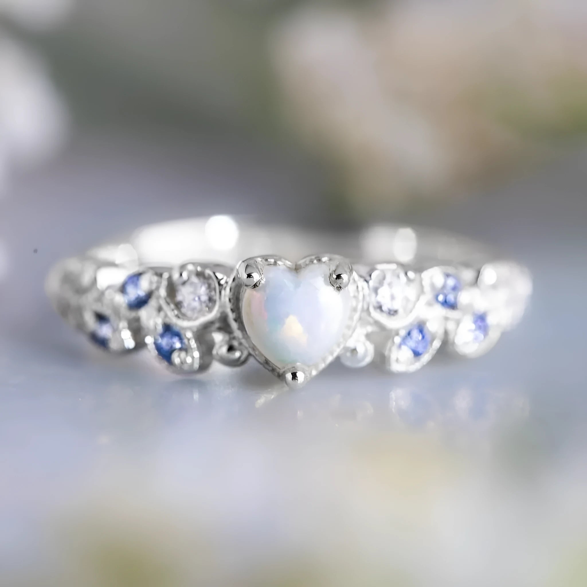 A white alloy heart-shaped ring for women on a plain background, showing the heart design.