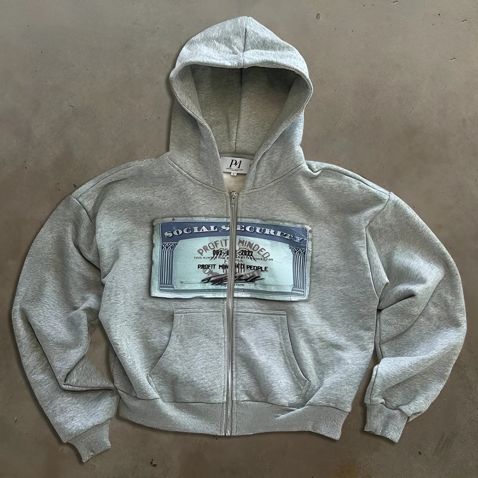 A loose-fitting black hooded zip-up jacket with a letter print design on the front.