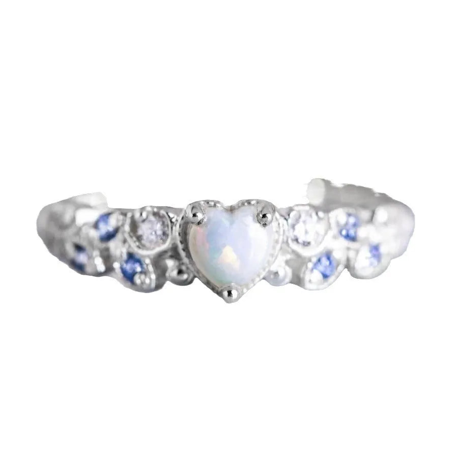 A white alloy heart-shaped ring for women on a plain background, showing the heart design.