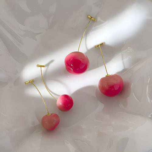 A pair of acrylic earrings shaped like detailed peaches on copper posts, shown in small and large size options.