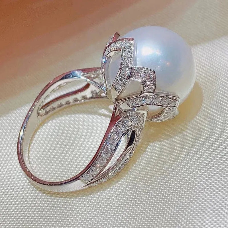 Copper female baroque pearl receptacle ring with inlaid zircon stones in white gold colour on white background