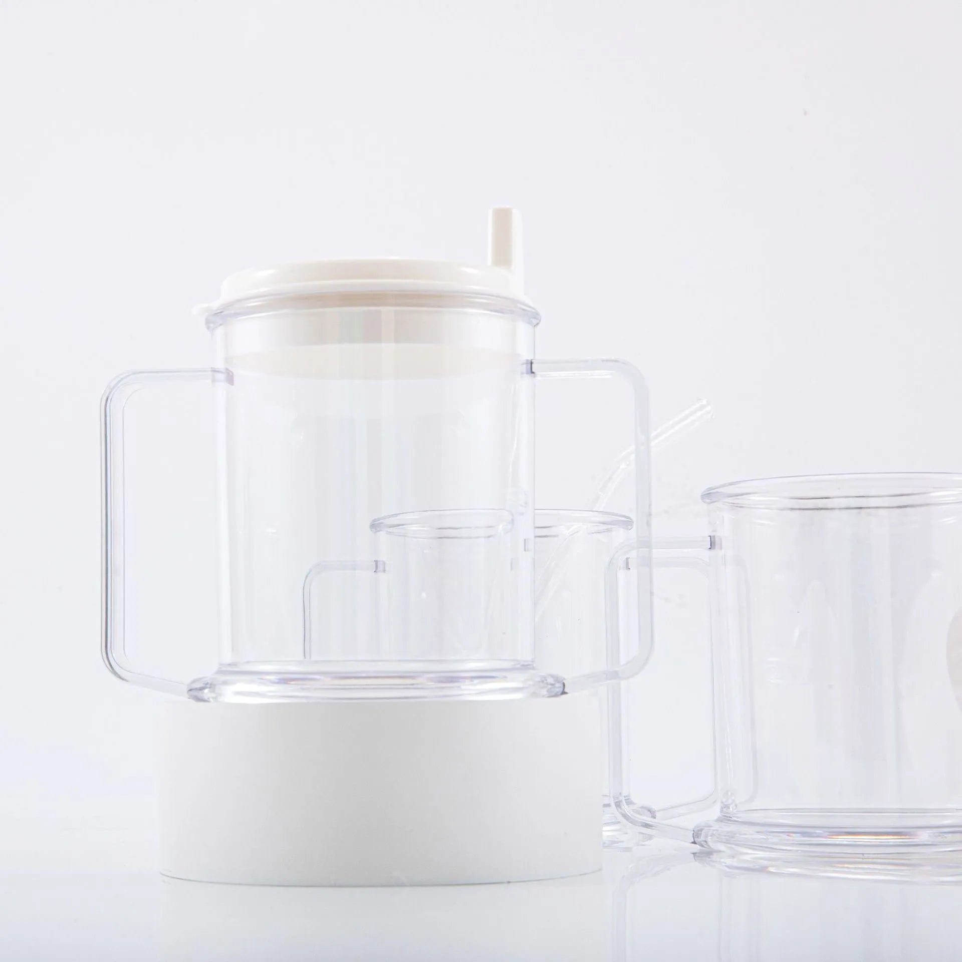 Transparent spill-proof plastic drinking cup on a plain background
