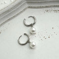 Geometric pearl earrings with titanium steel components and round pearl detailing