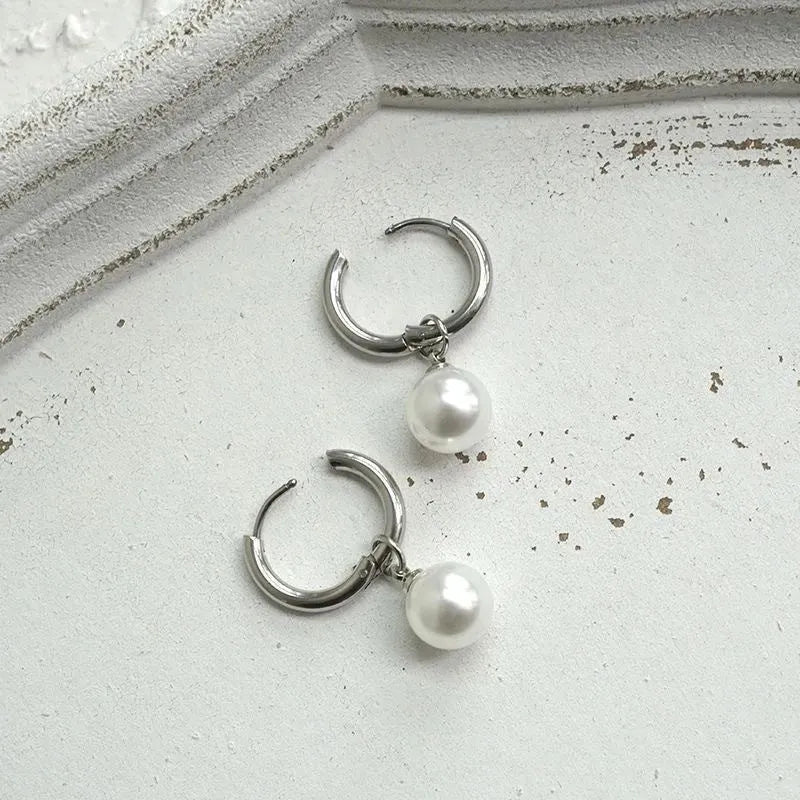 Geometric pearl earrings with titanium steel components and round pearl detailing