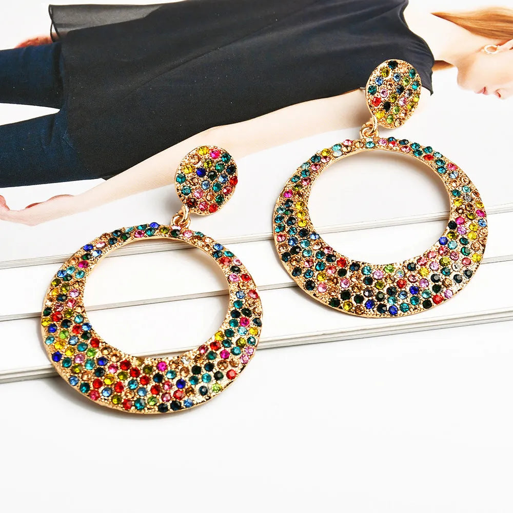 Colourful large pendant earrings with round diamond-shaped studs on a cartoon-style metal setting.