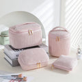 Set of four small pink cube-shaped flannelette makeup bags with zips, arranged together.