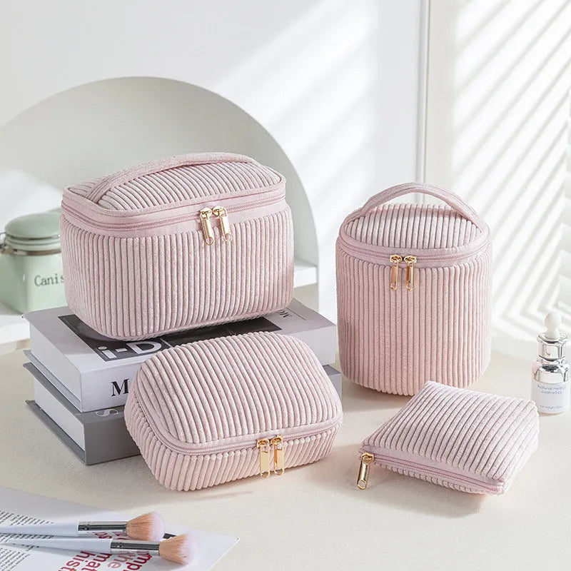 Set of four small pink cube-shaped flannelette makeup bags with zips, arranged together.