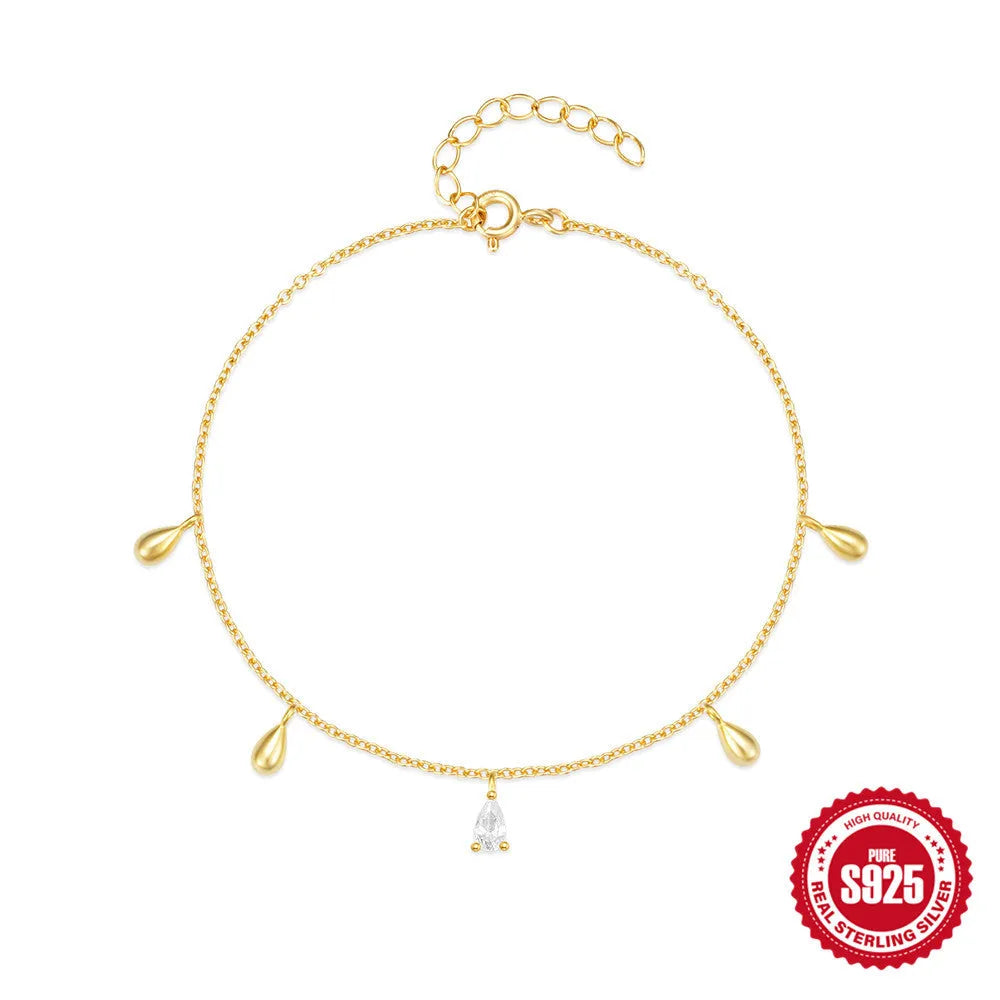 S925 sterling silver bracelet with gold tone water drop diamond pendant on a wrist.