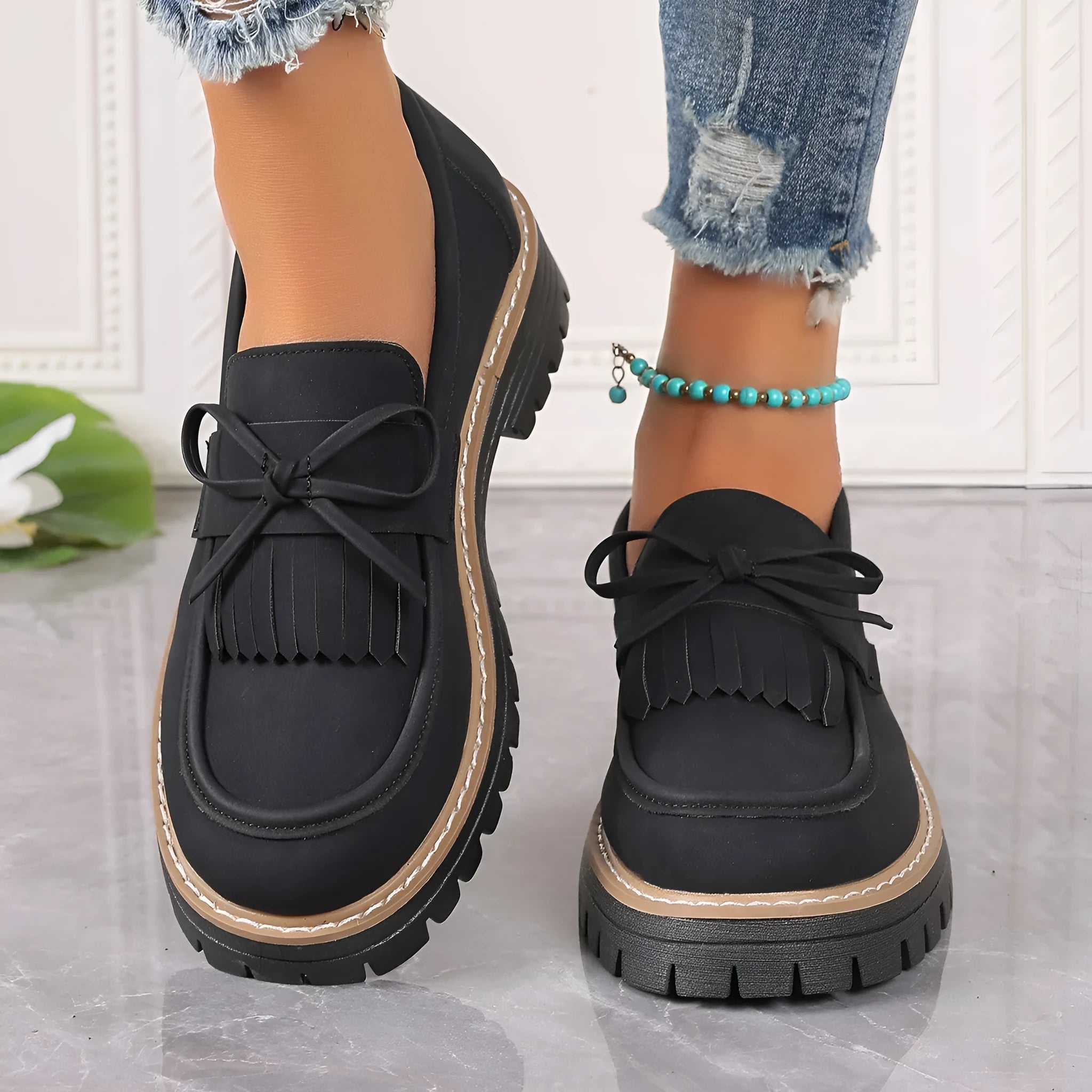 Black plus size women's loafers with a tassel and bowknot on the flat chunky heel.