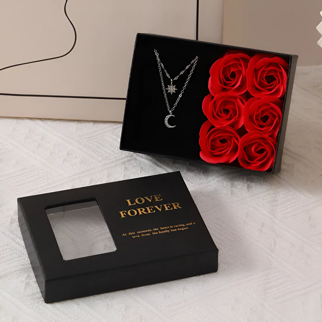 Red Valentine's gift box open to show six pink soap roses with a matching handbag beside it
