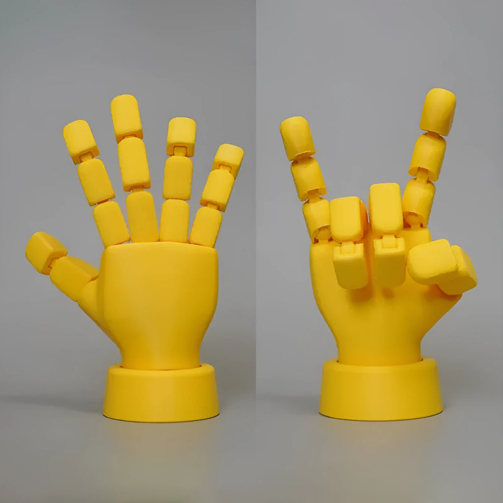 Yellow articulated hand prop ornament with movable joints on a desk, showing poseable fingers and measuring 5cm wide.
