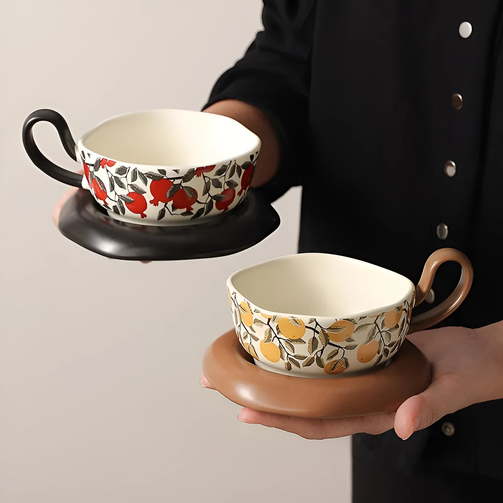 Antique-style ceramic coffee cup and saucer set with a retro pattern in either black or orange.