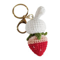 Hand-woven white doll wire pendant with rabbit and strawberry design and an attached key.