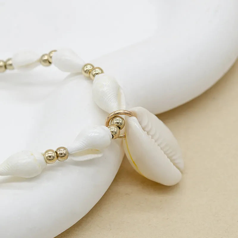 White conch shell bead necklace with a mother of pearl pendant on a regular chain.