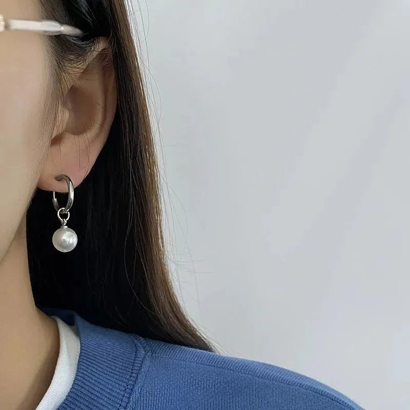 Geometric pearl earrings with titanium steel components and round pearl detailing