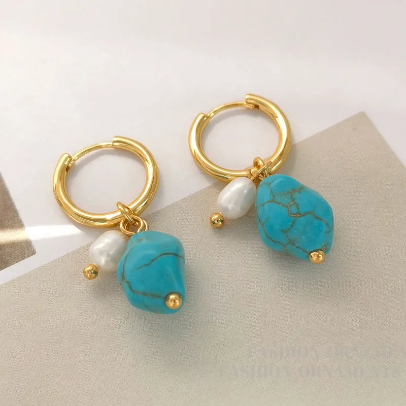 A pair of geometric clip-on earrings made of copper with turquoise and cultured pearls.