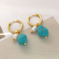 A pair of geometric clip-on earrings made of copper with turquoise and cultured pearls.