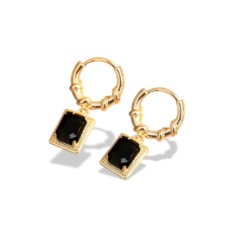 Close-up of women's geometric quadrilateral copper earrings with a black zircon stone and butterfly back.