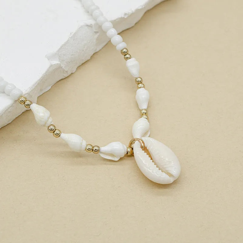 White conch shell bead necklace with a mother of pearl pendant on a regular chain.