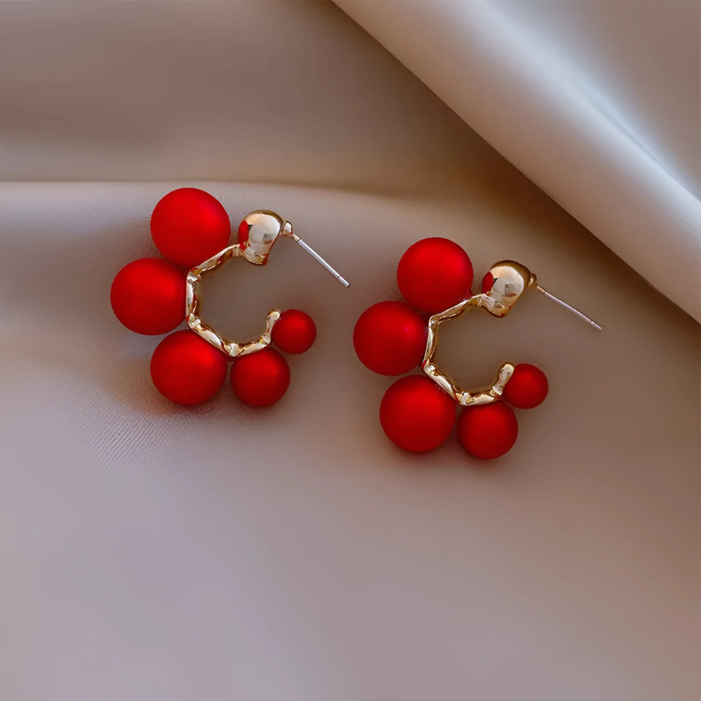 A pair of red bell-shaped drop earrings for women, made from metal alloy.