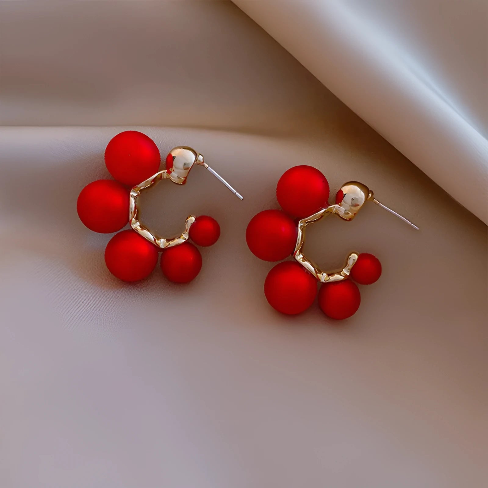 A pair of red bell-shaped drop earrings for women, made from metal alloy.