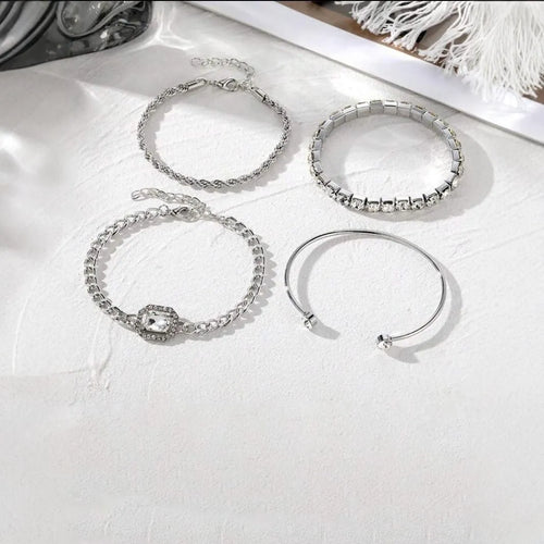 Set of four women's alloy bracelets with geometric square diamond charms and metal chains in gold or silver.