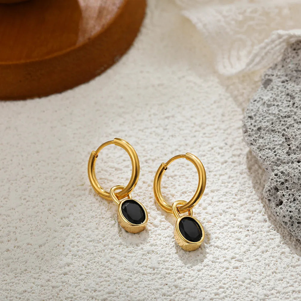 Women's oval zircon clip earrings in army green with polished copper setting on a white background.
