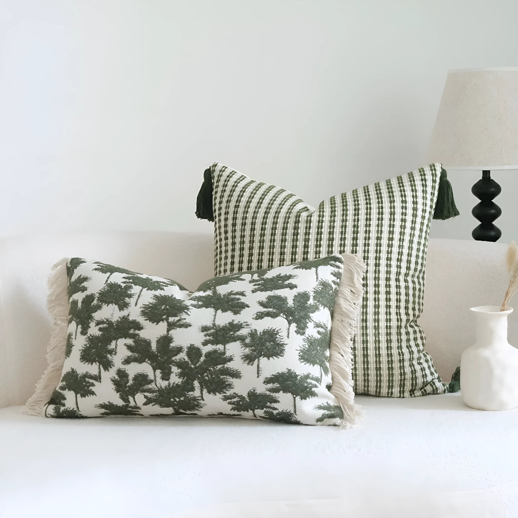 Green cotton linen decorative pillow with tassel, featuring a botanical leaf pattern, for hotel sample rooms.