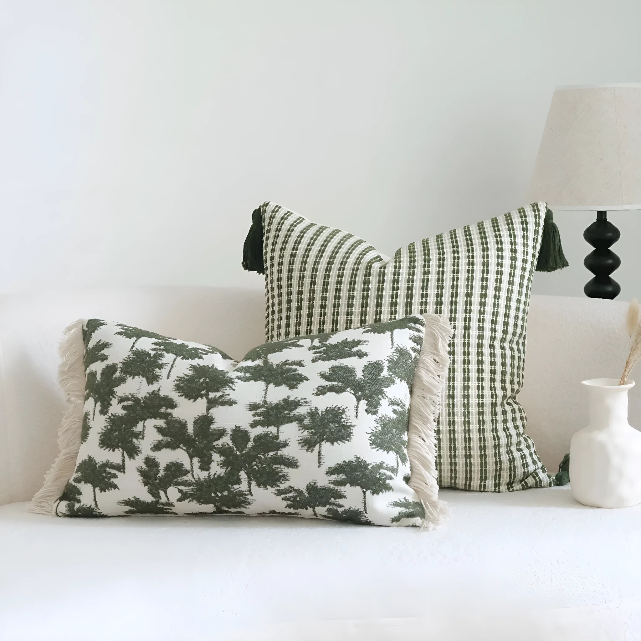 Green cotton linen decorative pillow with tassel, featuring a botanical leaf pattern, for hotel sample rooms.