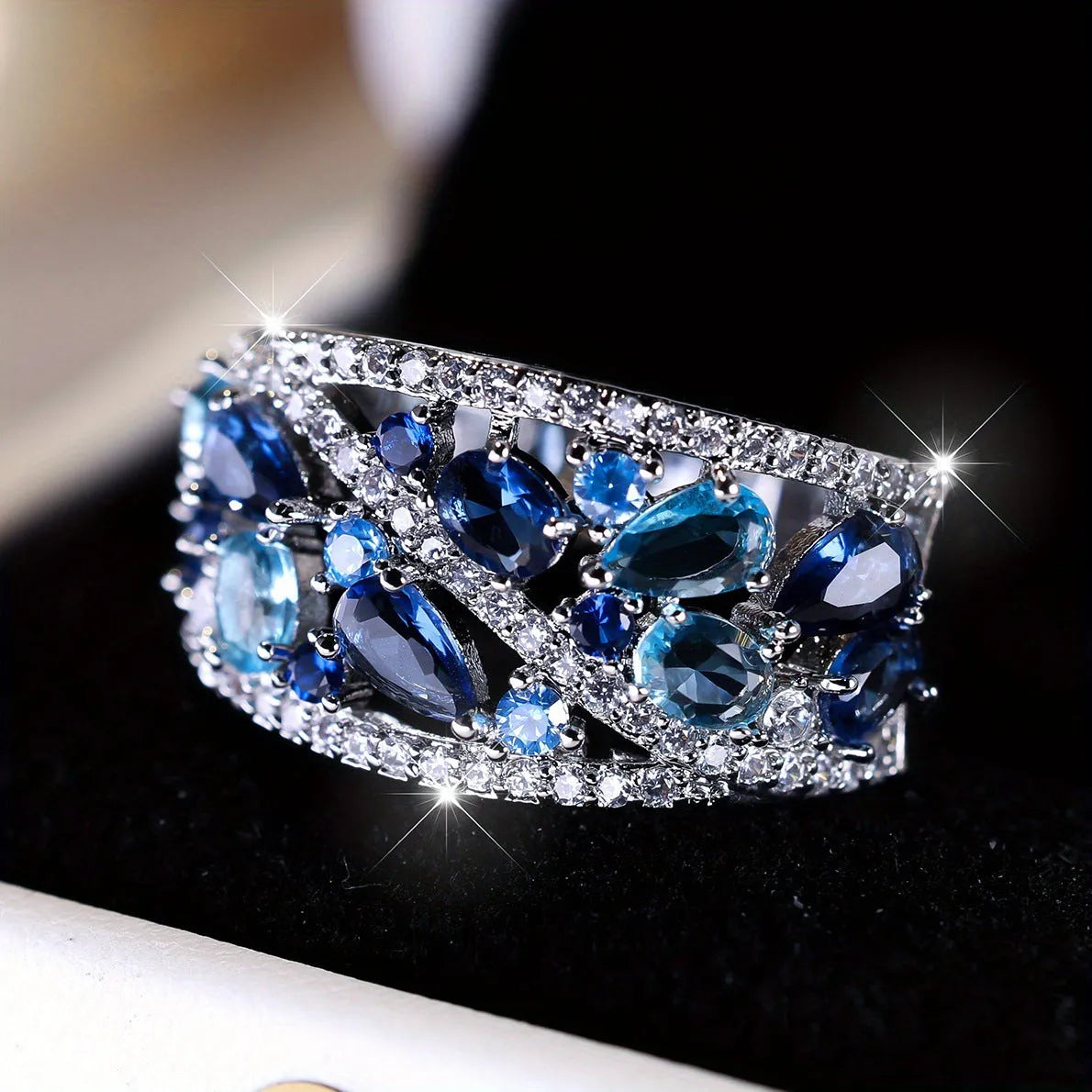 Women's round hollow copper fashion ring with a gemstone centrepiece, shown in gold and platinum colour options.