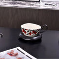 Antique-style ceramic coffee cup and saucer set with a retro pattern in either black or orange.