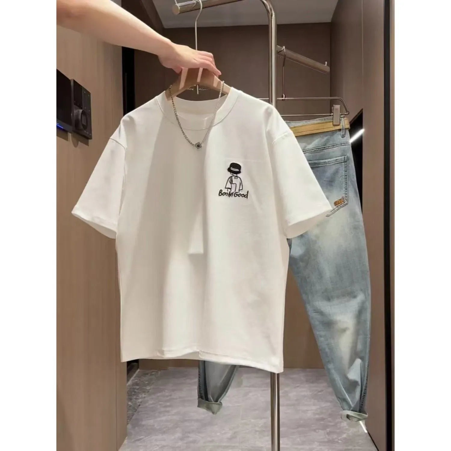 Man wearing a black slim fit pure cotton t-shirt with a simple cartoon print design on the front.