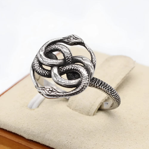 Steel coloured titanium steel double snake ring with a retro design on a finger.