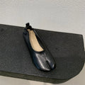 Women's black split toe horseshoe design pumps with a chunky low heel and round toe.
