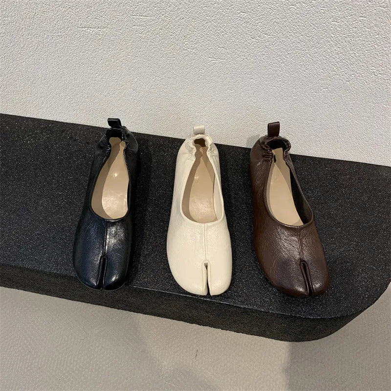 Women's black split toe horseshoe design pumps with a chunky low heel and round toe.