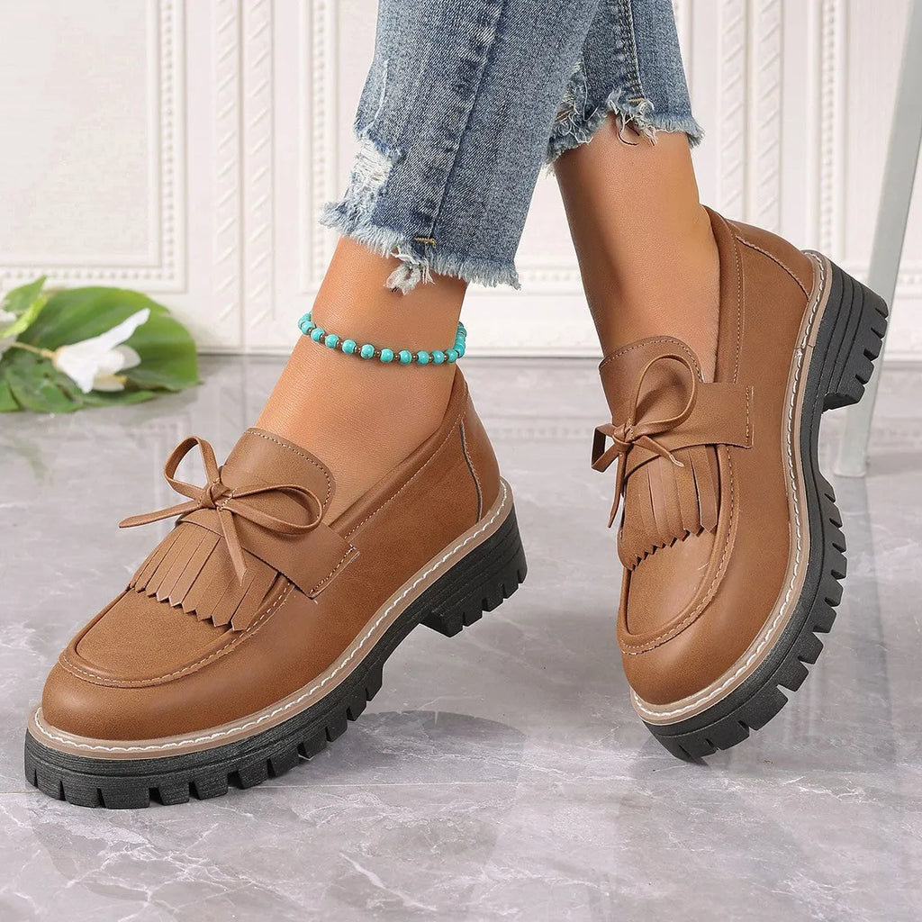 Black plus size women's loafers with a tassel and bowknot on the flat chunky heel.
