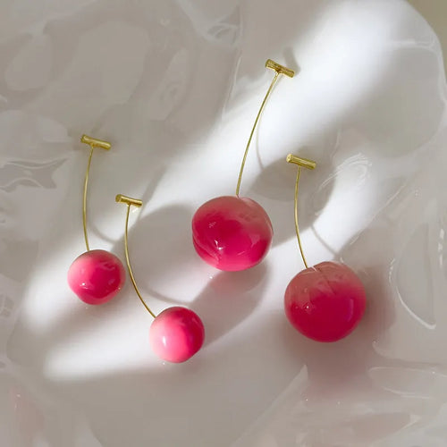 A pair of acrylic earrings shaped like detailed peaches on copper posts, shown in small and large size options.