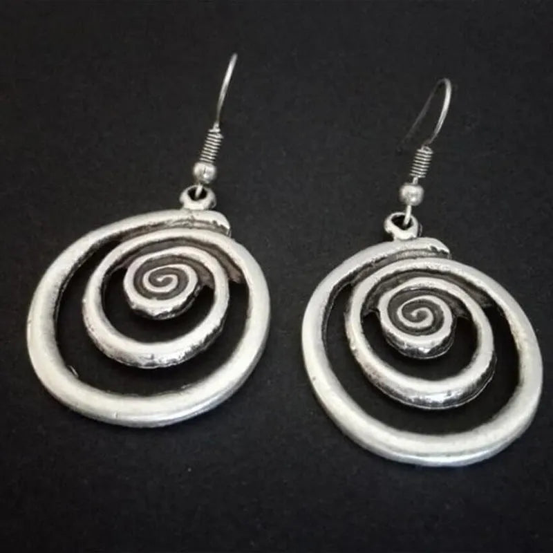 Pair of silver geometric spiral earrings with a distressed finish on a white background.