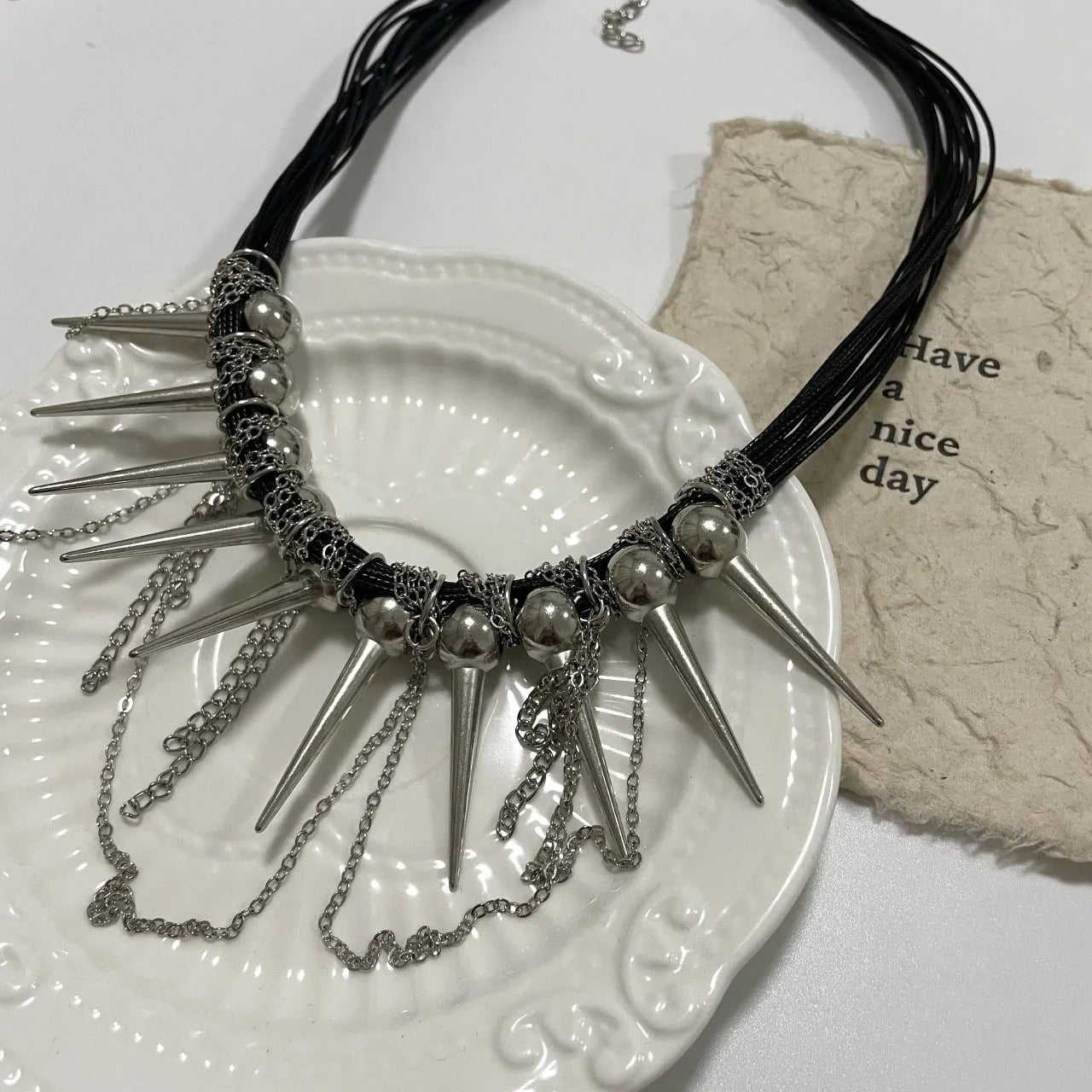 Women's leather necklace with electroplated rivet detail and winding tassel round beads design