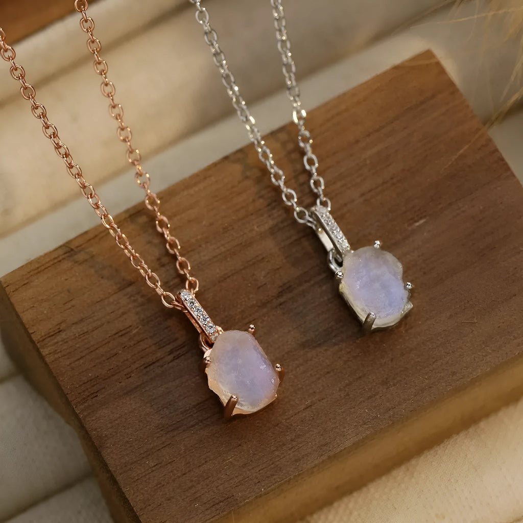 Close-up of a sterling silver necklace with a square moonstone pendant on an adjustable curb chain.