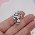 Close-up of a silver-tone alloy magpie charm pendant with engraved feather details on wings and tail for DIY jewellery.