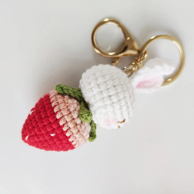 Hand-woven white doll wire pendant with rabbit and strawberry design and an attached key.