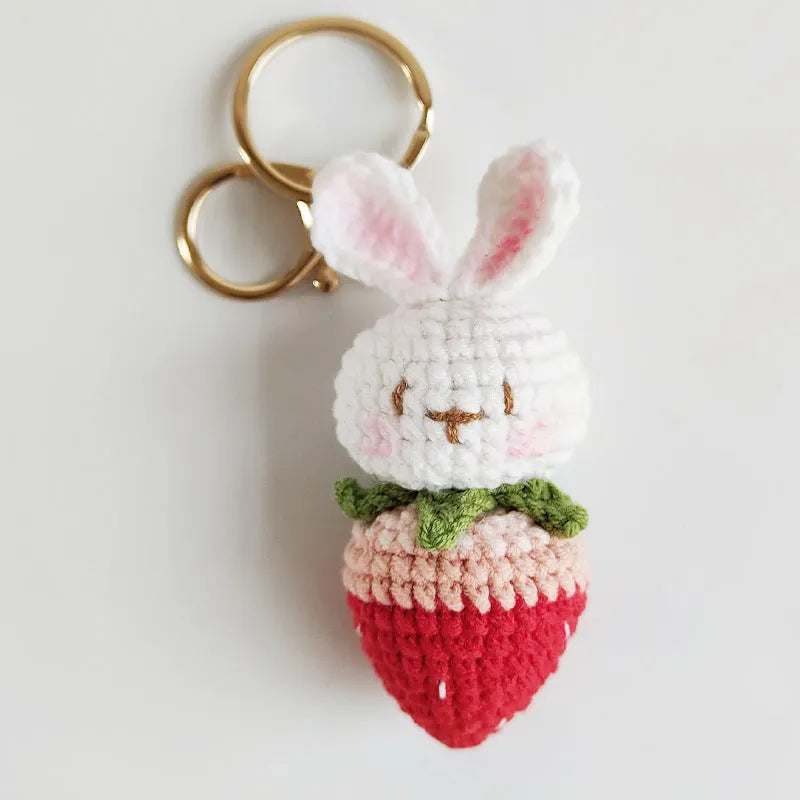 Hand-woven white doll wire pendant with rabbit and strawberry design and an attached key.