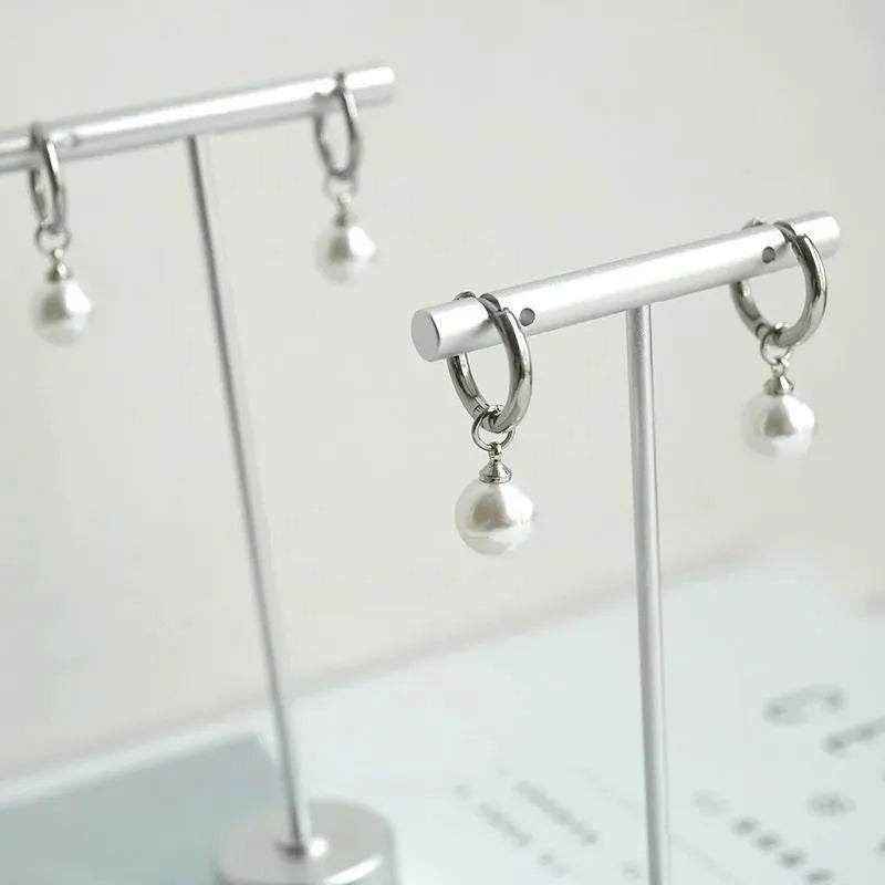 Geometric pearl earrings with titanium steel components and round pearl detailing
