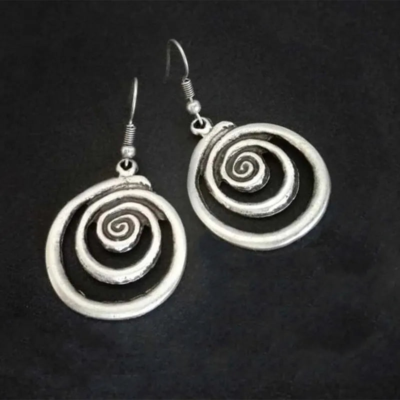 Pair of silver geometric spiral earrings with a distressed finish on a white background.