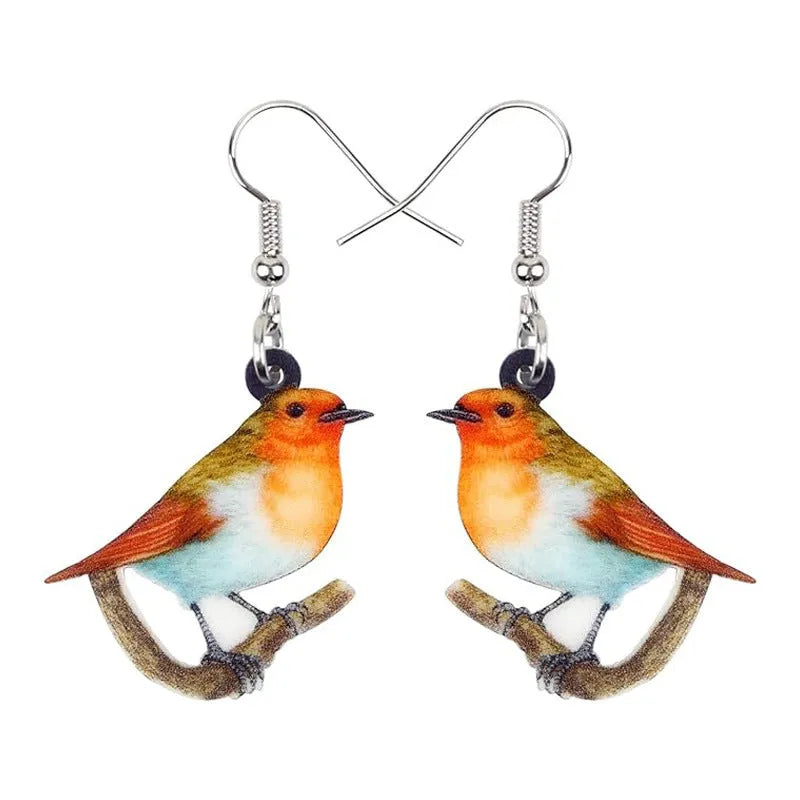 Pair of blue and white acrylic pendant earrings featuring a printed titmouse bird and snake design on geometric shapes.