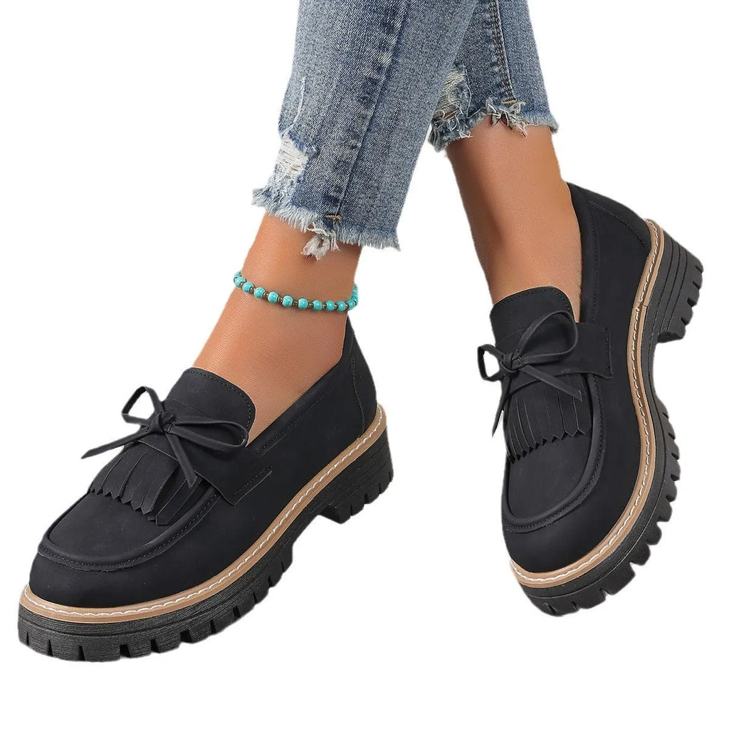 Black plus size women's loafers with a tassel and bowknot on the flat chunky heel.