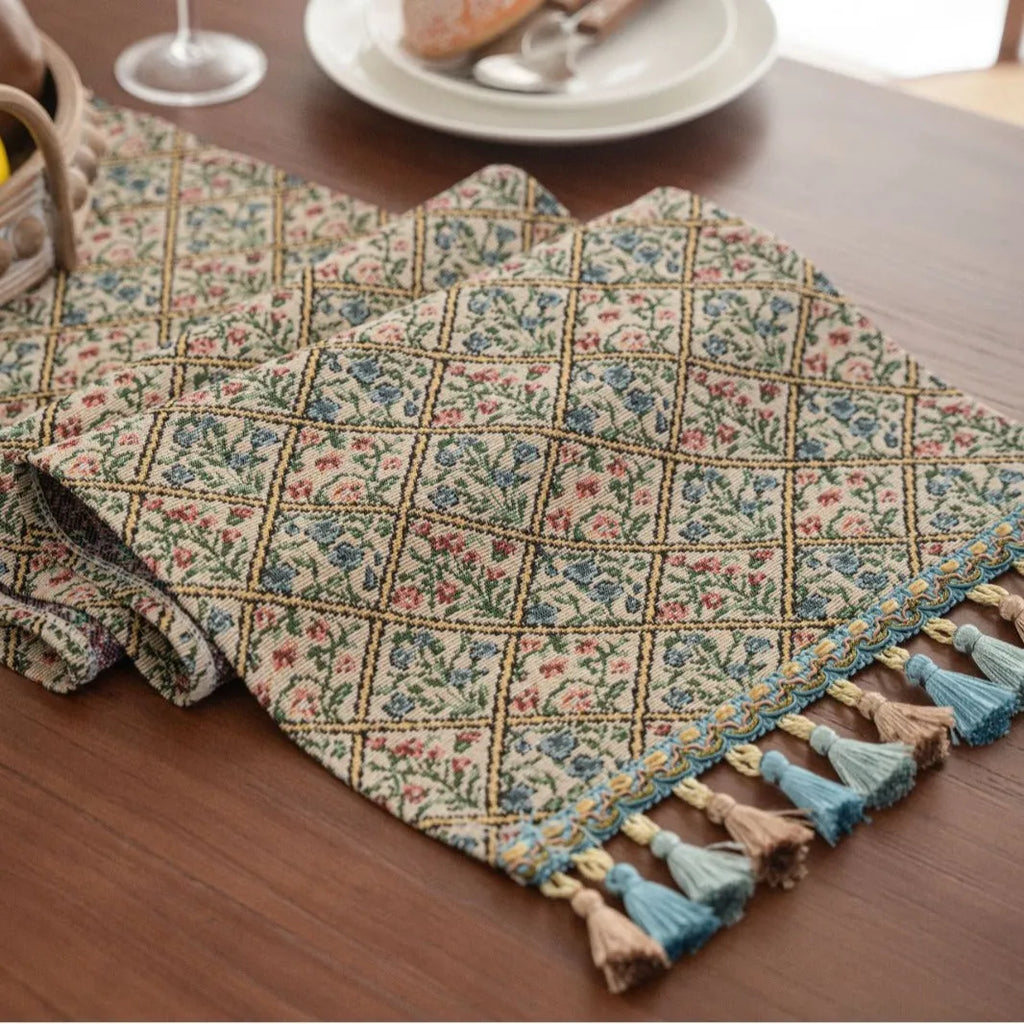 Dark blue Nordic stripe pattern jacquard table runner with tassel detail on a wooden table.